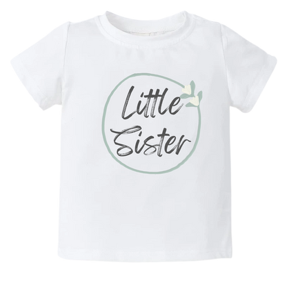 A kid's t-shirt with a minimalistic printed graphic of a pastel green floral wreath and the text 'Little Sister.' This charming t-shirt celebrates the joyous arrival of a little sister.