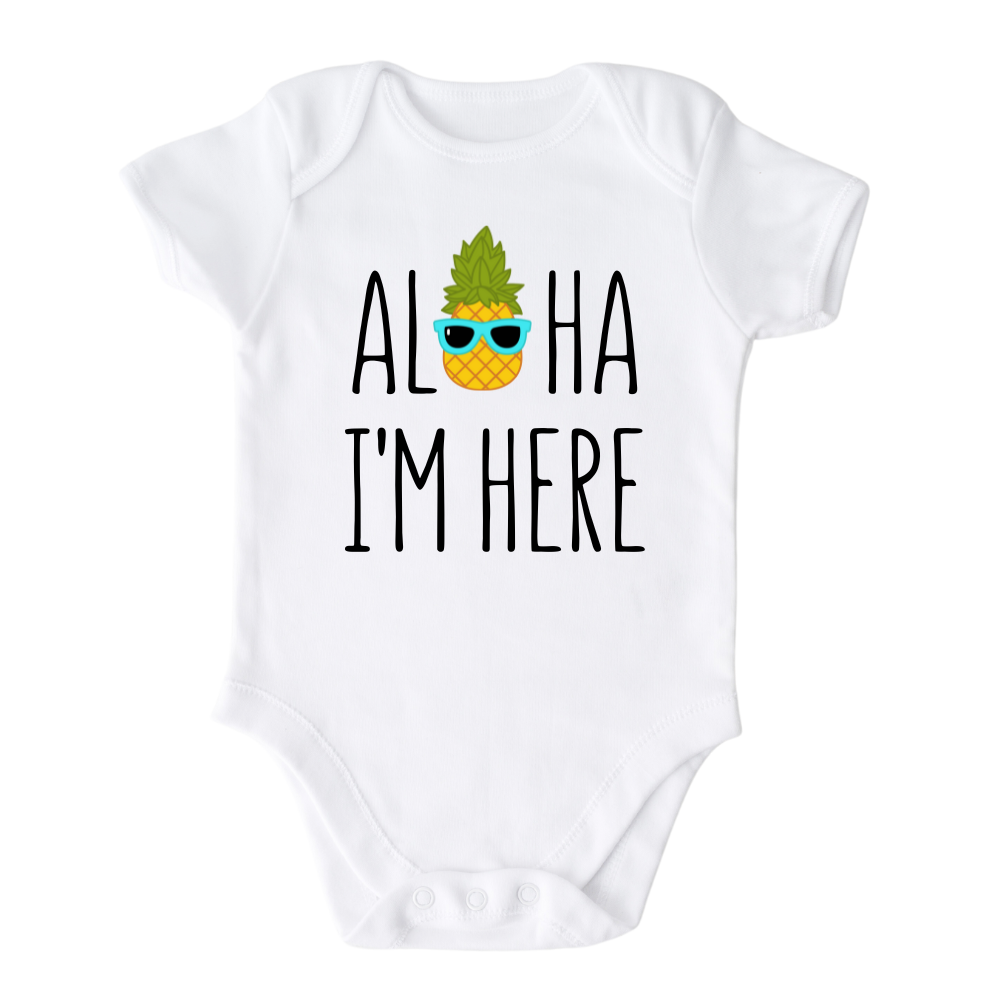 A kids' t-shirt with a pineapple wearing glasses and the text 'Aloha I'm Here.' This fun and tropical design captures the playful spirit, adding a vibrant touch to the wearer's style.