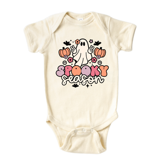 Natural onesie with a cute ghost graphic and the text 'Spooky Season.' Perfect for Halloween outfits and festivities. Shop now and let your little one embrace the spirit of Halloween with this fun and festive tee!