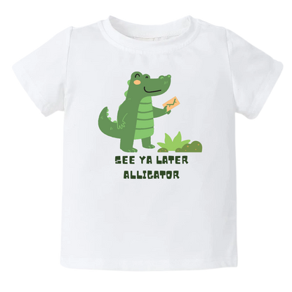 Kid's t-shirt showcasing a playful printed graphic of an alligator and the text 'See Ya Later Alligator.' Explore this delightful tee that adds a touch of whimsy and charm to your child's wardrobe.