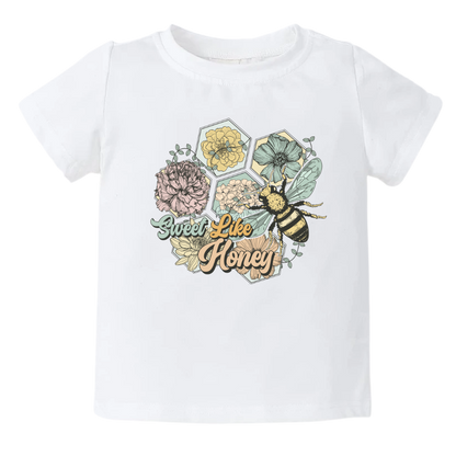 Kids' t-shirt with a cute retro graphic of flowers and bees, and the text 'Sweet Like Honey.' Trendy and playful design for stylish outfits. 