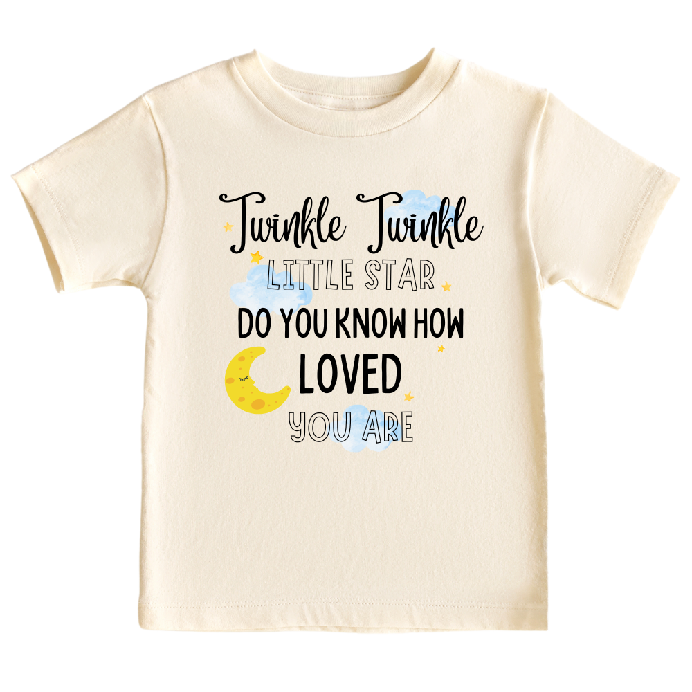 A kids' t-shirt with a captivating night sky graphic adorned with stars and a moon cup. The text reads 'Twinkle Twinkle Little Star, Do You Know How Loved You Are?' The design embodies a sense of magic, love, and wonder, inspiring imagination and admiration.