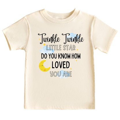 A kids' t-shirt with a captivating night sky graphic adorned with stars and a moon cup. The text reads 'Twinkle Twinkle Little Star, Do You Know How Loved You Are?' The design embodies a sense of magic, love, and wonder, inspiring imagination and admiration.