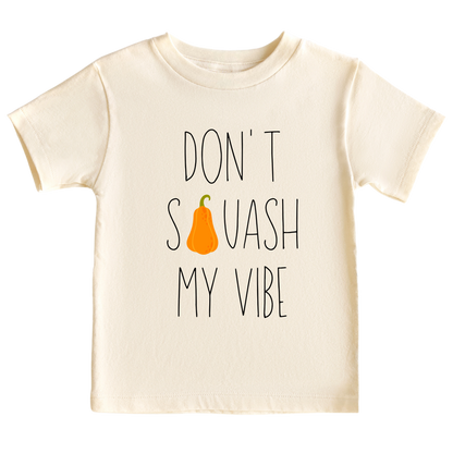 Natural Kid's t-shirt featuring a fall-themed printed graphic of a squash and the fun text 'Don't Squash My Vibe.' Explore this trendy tee, perfect for embracing autumn style. 