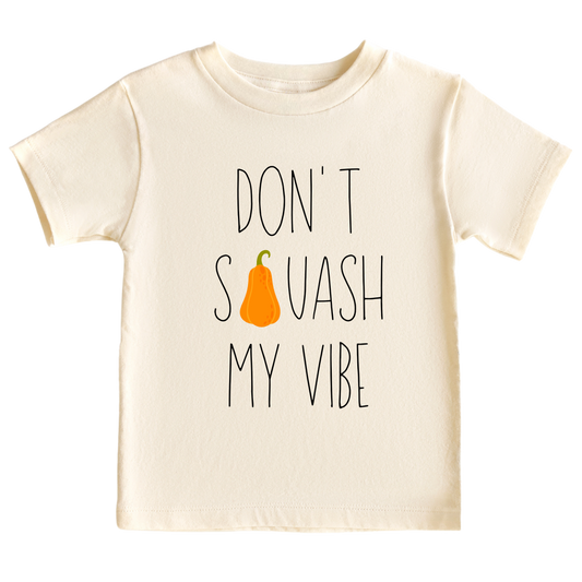 Natural Kid's t-shirt featuring a fall-themed printed graphic of a squash and the fun text 'Don't Squash My Vibe.' Explore this trendy tee, perfect for embracing autumn style. 