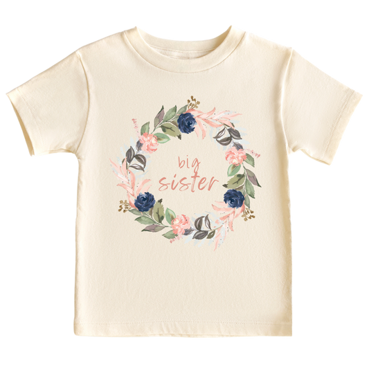 A kid's t-shirt with a cute printed graphic of a floral wreath and the text 'Big Sister.' This adorable t-shirt celebrates the special role of being a big sister. Made with high-quality materials, it offers comfort and durability, making it a perfect addition to any child's wardrobe.